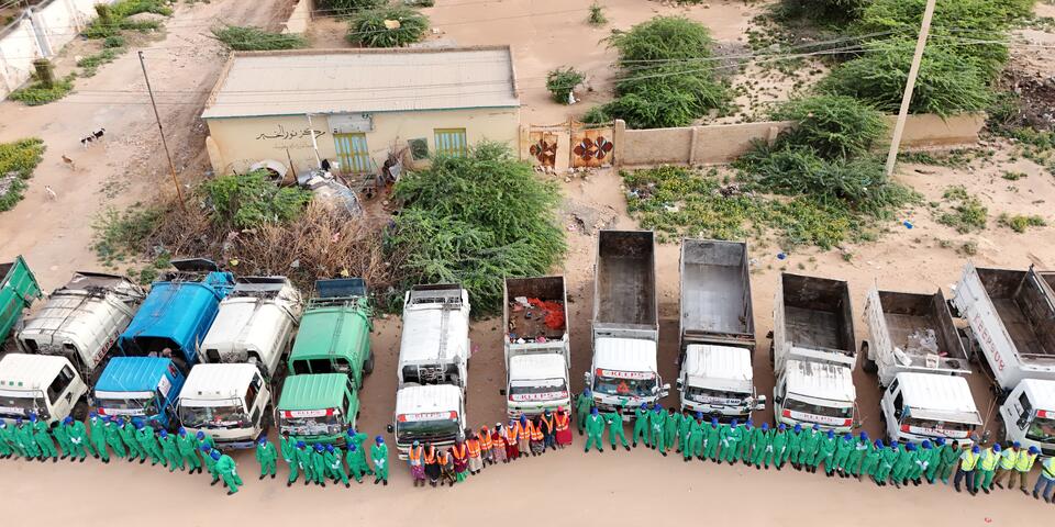Overhead shot of KEEPS employees lined up nicely in front of the work trucks