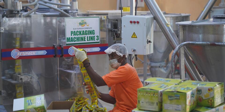 ILO Tango employee boxing up drink mix packets in manufacturing facility