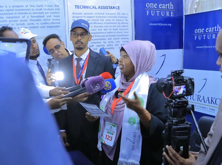 Sahra speaking into a microphone at the Somaliland Investment Expo