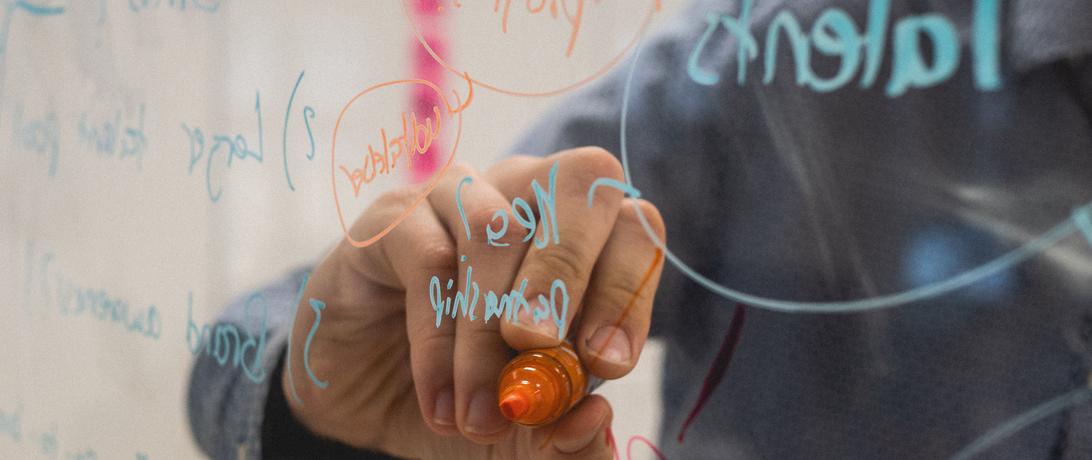 Person writing on a white board