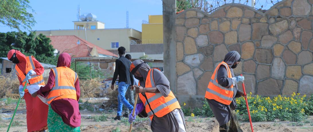 Female KEEPS employees working to clean up a beach area