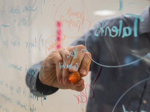 Person writing on a white board