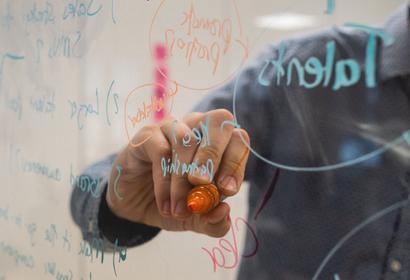 Person writing on a white board